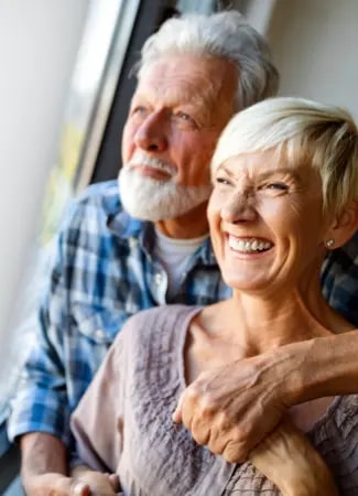 Happy senior couple in love hugging and bonding with true emotions at home.png